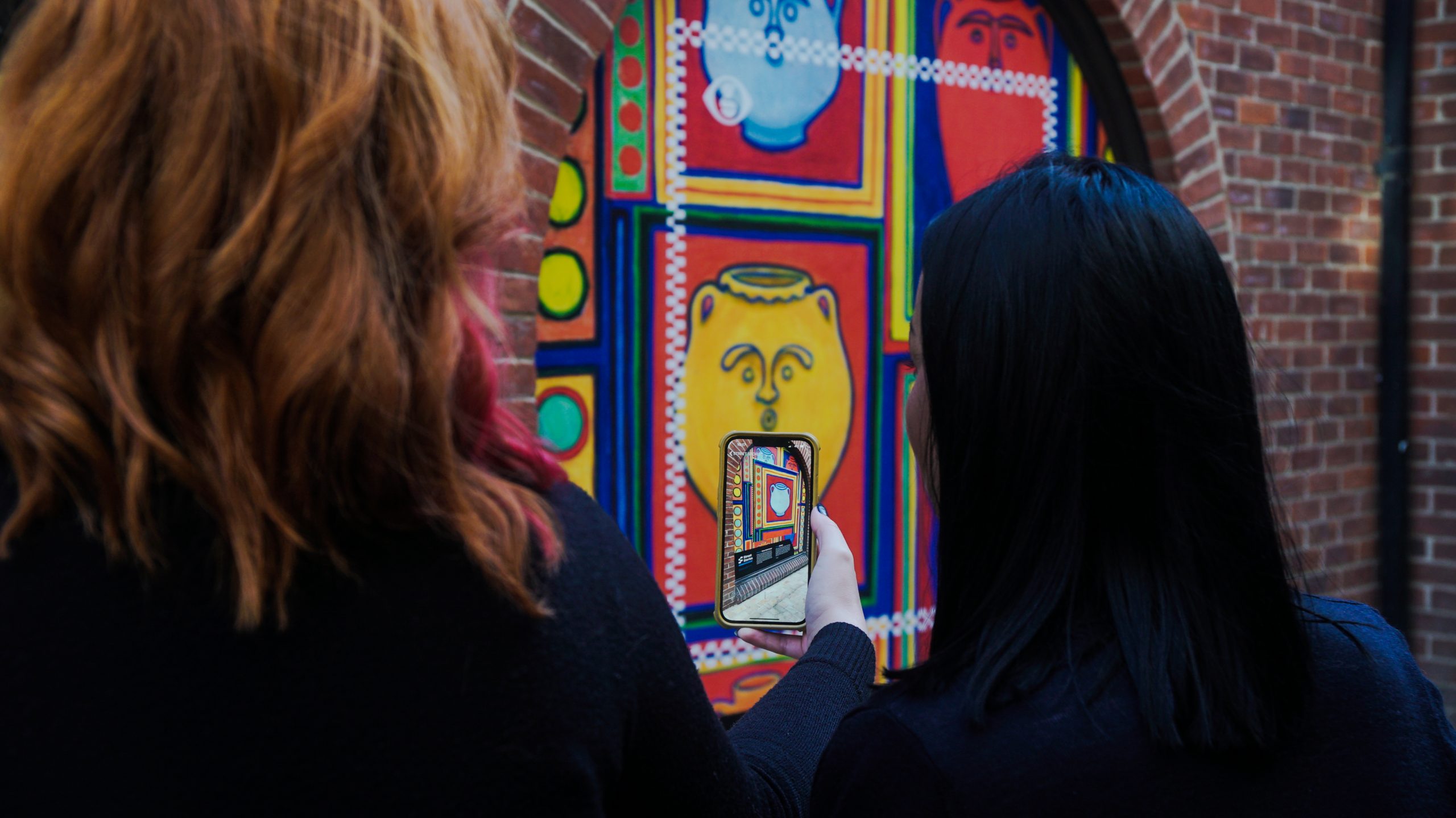 Two women looking at the Street Stories installation by Colchester artist Ella Blaxill